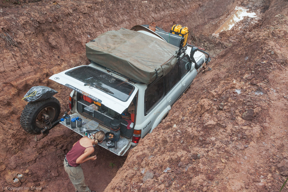 Sheri Makes Dinner on the Tailgate of the Truck While Camping in the Middle of the Road in Cameroon