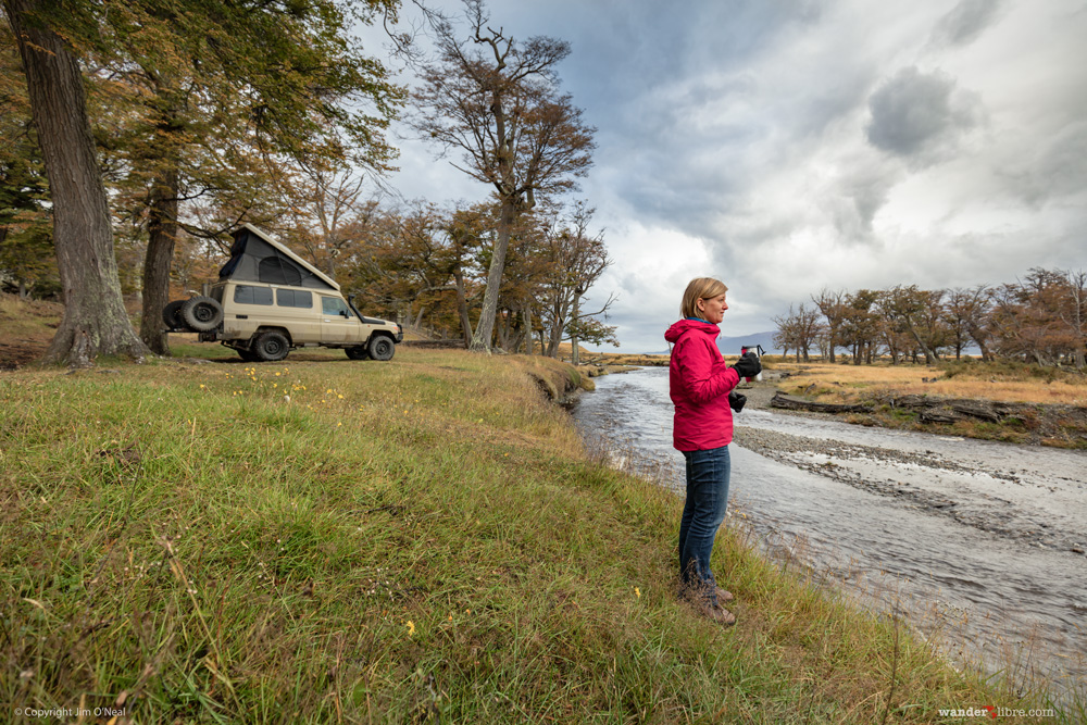 Camping in our Land Cruiser Troopy along a tranquil river in Estancia Haberton after traveling to the terminus of the most southerly road in South America.